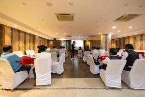 a group of people sitting at tables in a room at Foxoso The BMK - A Corporate Hotel in New Delhi