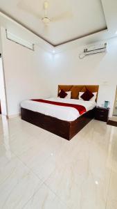a bedroom with a bed in a white room at Hotel Dream Palace in Mysore
