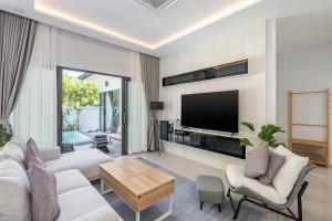 a living room with a couch and a tv at Harmony Pool Villa Ao Nang in Ao Nang 