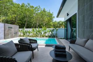 a patio with chairs and a swimming pool at Harmony Pool Villa Ao Nang in Ao Nang 