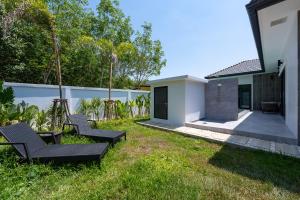 a yard with two chairs and a house at Harmony Pool Villa Ao Nang in Ao Nang 