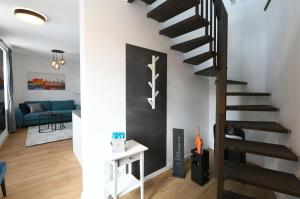 a spiral staircase in a living room with a blue couch at Apartment Schweriner Lieblingsplatz in Schwerin