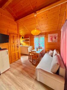 a living room with a couch and a table at Domki letniskowe Nadia in Grzybowo