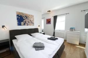 a bedroom with a large white bed with towels on it at Apartment Schweriner Lieblingsplatz in Schwerin +10 photos