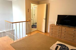 a living room with a flat screen tv and a dresser at Maria Apartment Tolli põik in Kuressaare +7 photos