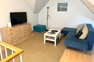 a living room with a blue couch and a tv at Maria Apartment Tolli põik in Kuressaare