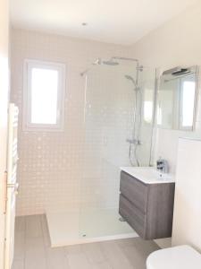 a white bathroom with a shower and a sink at Résidence San Pancraziu in LʼÎle-Rousse +14 photos