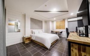 a bedroom with a white bed and a desk at Cats Hotel in Puch'ŏn-yŏk +23 photos
