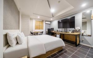 a bedroom with a bed and a desk and a television at Cats Hotel in Puch'ŏn-yŏk