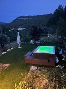 a swimming pool in a yard with an umbrella at Casa Rural La Garcia in Puebla de Arenoso