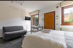 a bedroom with a bed and a chair and a table at Monolocale con giardino privato e cucina completa in Bergamo