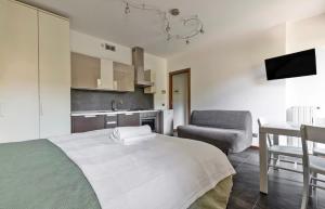 a bedroom with a bed and a table and a chair at Monolocale con giardino privato e cucina completa in Bergamo