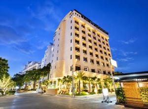 a tall white building with palm trees in front of it at The Palazzo Hotel in Bangkok