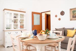 a dining room with a table and a couch at Le Dimore del Finoglio in Conversano