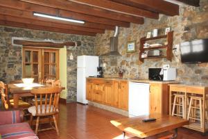 a kitchen with a table and a white refrigerator at La Llosa II in Villaviciosa