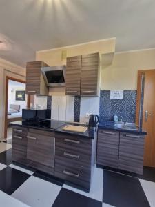a kitchen with wooden cabinets and black counter tops at Centrum Noclegowe II in Bydgoszcz