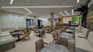 a restaurant with tables and chairs and a bar at AL MIDYAF Appart'Hôtel in El Jadida