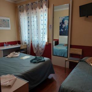 a hotel room with two beds and a mirror at Villa Morgante B&B in Pedara