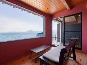 a room with a bench and a view of the ocean at Costa Del Sol HIJI in Hiji