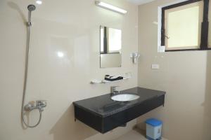 a bathroom with a black sink and a shower at Nhà Khách TW in Hanoi