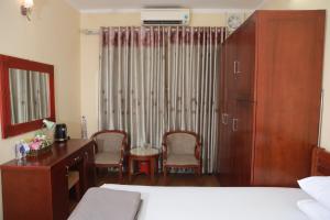 a bedroom with a desk and a bed and a dresser at Nhà Khách TW in Hanoi