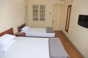 a room with two beds and a tv on the wall at Nhà Khách TW in Hanoi +20 photos
