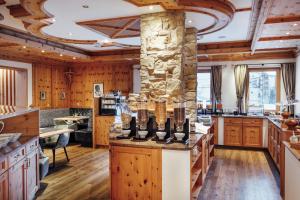 a large kitchen with wooden cabinets and a stone pillar at Chasa Castello relax & spa in Samnaun
