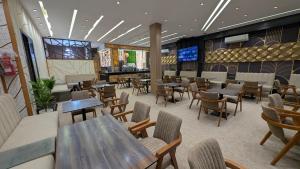 a restaurant with tables and chairs and a bar at AL MIDYAF Appart'Hôtel in El Jadida