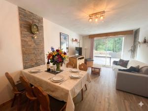 a living room with a table with flowers on it at Appartement in Vielle-Aure