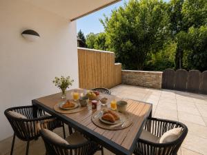 a wooden table with plates of food on a patio at Appartement in Vielle-Aure