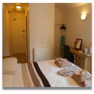 a bedroom with a bed with two towels on it at The Queens Head in Llanidloes