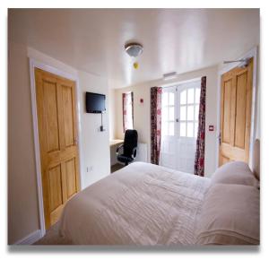 a bedroom with a bed and a television and a window at The Queens Head in Llanidloes