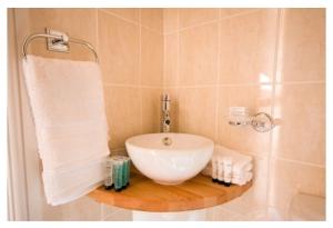 a bathroom with a sink and a shower with towels at The Queens Head in Llanidloes