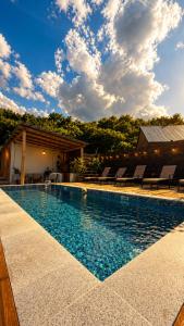 a swimming pool with chairs and a house at Winery & Brewery - Family Guesthouse "Villa Rbona" in Khashuri