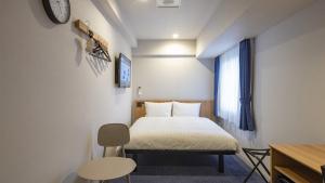 a small bedroom with a bed and a window at Toyoko Inn Kitakami-eki Nishi-guchi in Kitakami