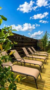 a row of lounge chairs on a wooden deck at Winery & Brewery - Family Guesthouse "Villa Rbona" in Khashuri