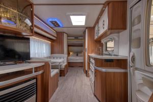 an rv kitchen with a sink and a bedroom at Kemping Molo Surf by Q4Camp in Jastarnia