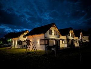 a house with a ladder in front of it at night at Białe Domki Mrzeżyno, wypoczynek w ciszy i zieleni in Mrzeżyno