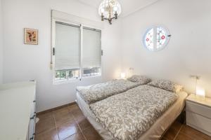 a white bedroom with a bed and a window at Casa Paula in Mazarrón