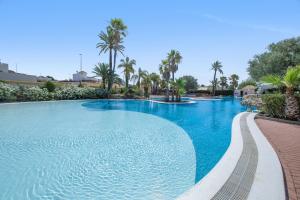 a swimming pool with blue water and palm trees at Casa Paula in Mazarrón