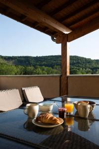 a table with a breakfast of croissants and orange juice at Le Refuge aux Portes du Vercors in Jaillans