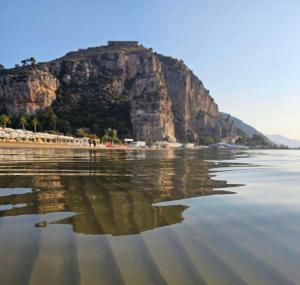 a view of a beach with a mountain in the background at Anxur Apartment in Terracina