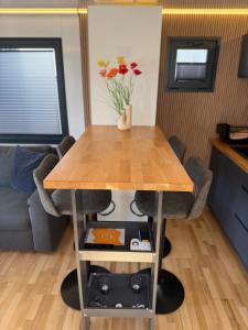 a table in a living room with a couch and flowers at Hausboot mit Sauna - TraumZeitBoot Heidi - exklusiver Festlieger in perfekter Lage am Scharmützelsee Bad Saarow in Bad Saarow