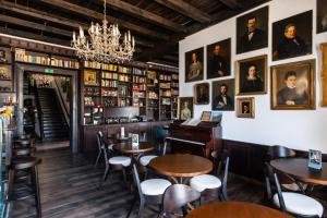 a restaurant with tables and chairs and portraits on the wall at Mr Görgey Art Hotel in Visegrád