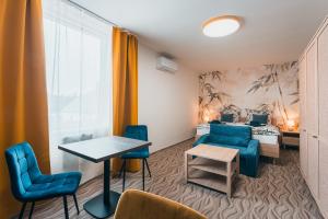 a room with two beds and a table and chairs at Hotel Mauricius in Příbram
