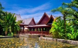 a house with a pond in front of it at Yalong Bay Mangrove Tree Resort in Sanya