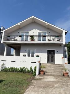 a white house with a balcony and stairs at EmiLiza in Kobuleti