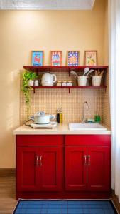 a kitchen with red cabinets and a sink at Rustic Homestay Bình Dương in Phú Lợi