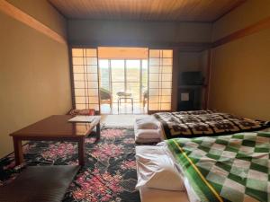 a room with two beds and a table and a table at Mizubaso in Gujo