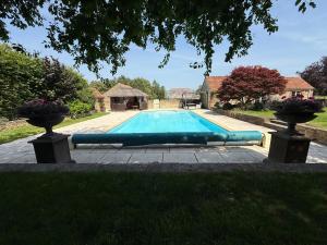 a swimming pool in the middle of a yard at Granary Cottage in Chippenham